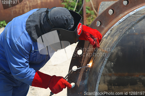 Image of A welder working with a metal pipe