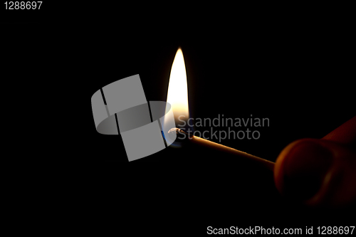 Image of Hand holding a burning matchstick