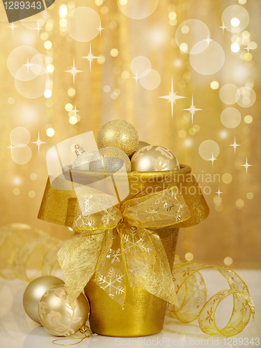 Image of christmas baubles in gold vase