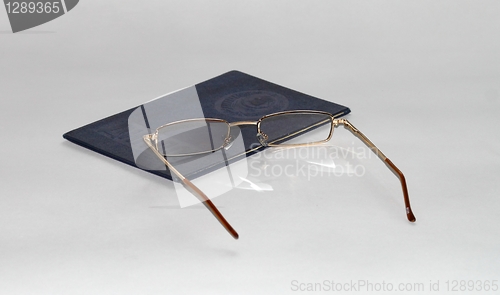 Image of diploma of education and glasses