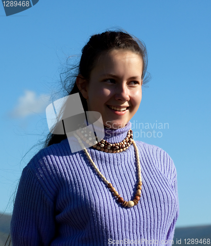 Image of Beautiful girl in a necklace laughs