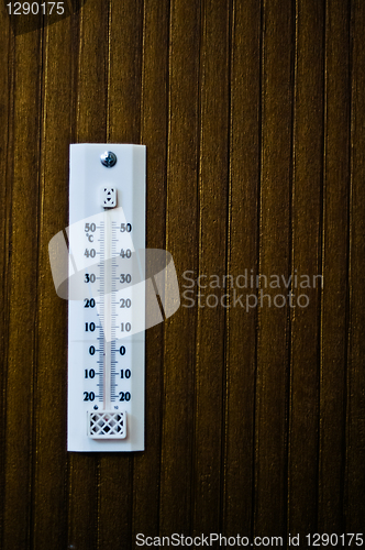 Image of room thermometer on a wooden wall close up