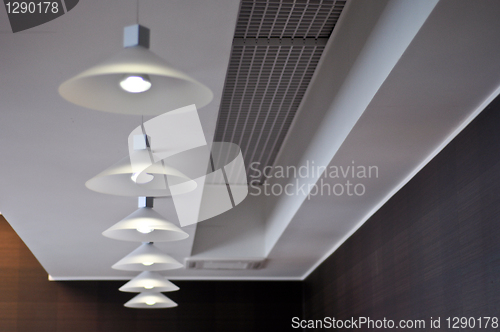 Image of several modern chandeliers on the ceiling in the bar