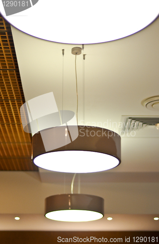 Image of several modern chandeliers on the ceiling in the bar