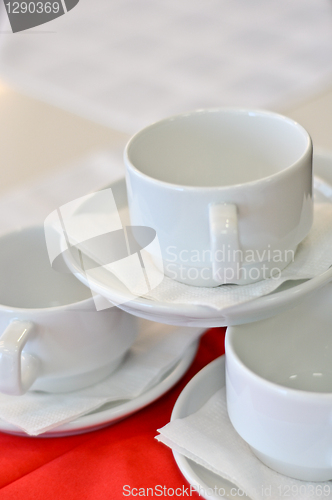 Image of three white porcelain tea cups and saucers and napkins