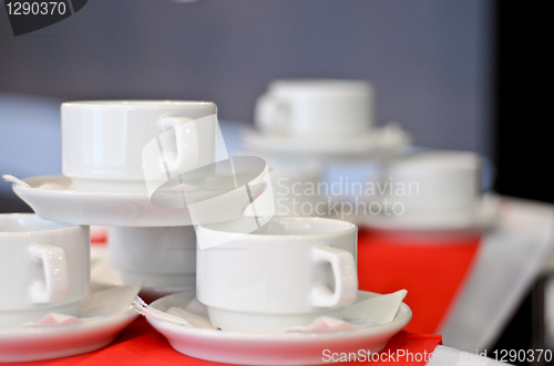 Image of three white porcelain tea cups and saucers and napkins close up