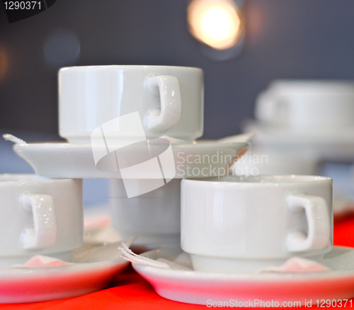 Image of three white porcelain tea cups and saucers and napkins close up