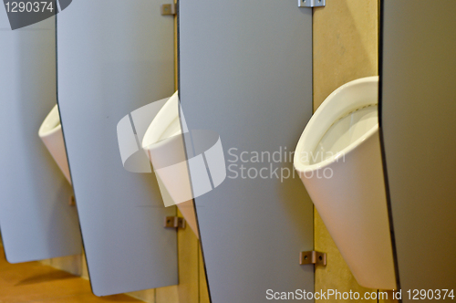 Image of Urinals behind partitions in a toilet in office building