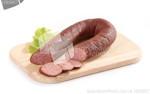 Image of smoked sausage and lettuce on wooden cutting board
