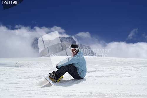 Image of Snowboarder resting on the ski slope