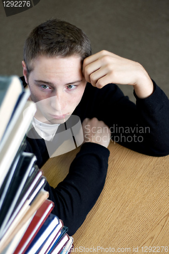 Image of Overloaded Student Looking At Pile of Books