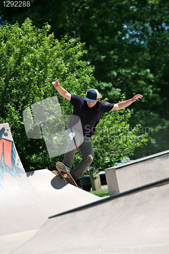 Image of Skateboarder Riding Up a Concrete Skate Ramp