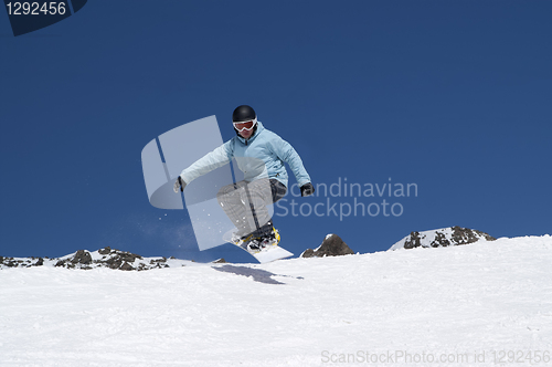 Image of Snowboarder jumping in the mountains