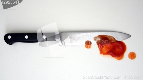 Image of knife with red blood from murder