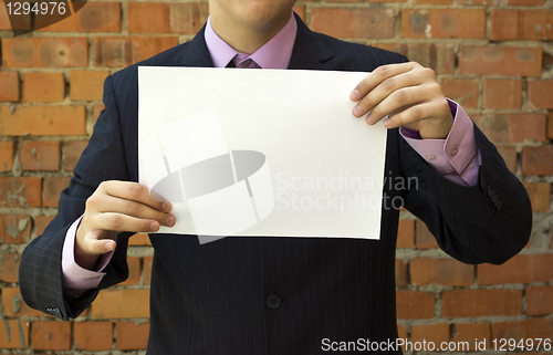 Image of Business man holding a blank white sheet of paper