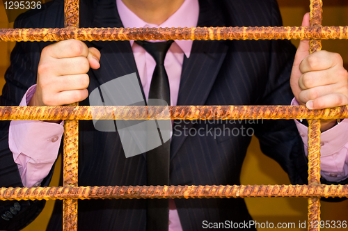 Image of Man. Behind An Iron Lattice