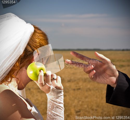 Image of apple offers the bride to the groom