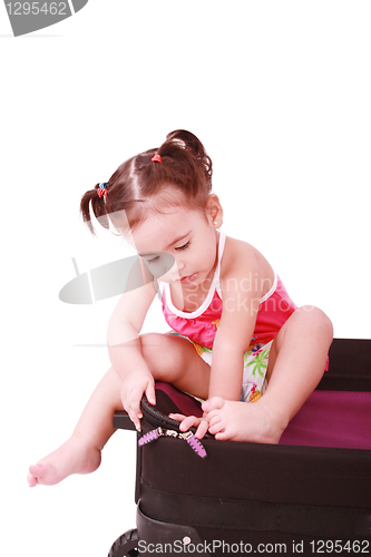 Image of Little girl in a suitcase. Isolated on a white background 