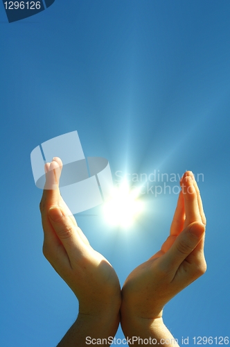 Image of hand sun and blue sky