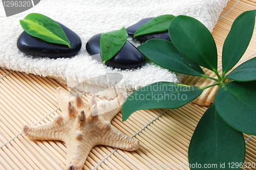 Image of foldet white bath towel and zen stones