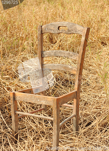 Image of broken chair on yellow grass