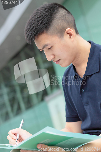 Image of casual asian businessman texting on his book. 