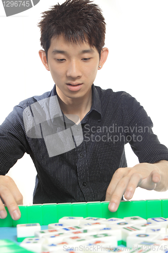 Image of Chinese man play Mahjong, traditional China gamble. 