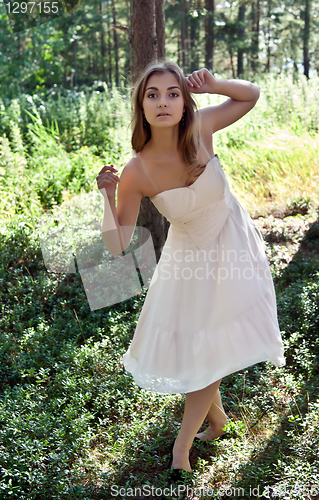 Image of girl in a cream dress in a forest