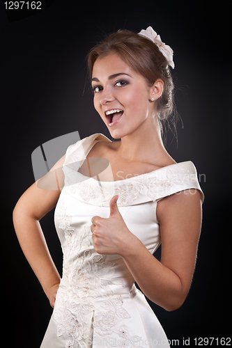 Image of Beautiful girl in dress shows OK in the studio