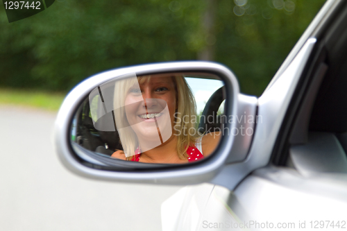 Image of Woman looking in a Car Mirror