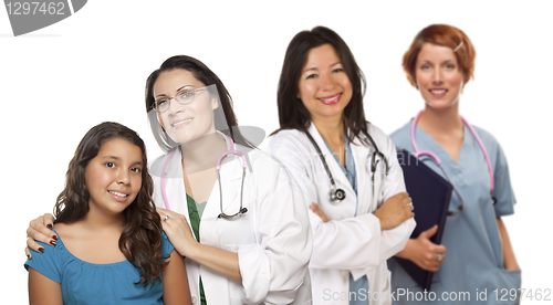 Image of Hispanic Female Doctor with Child Patient and Colleagues Behind