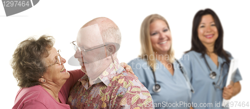 Image of Senior Couple with Medical Doctors or Nurses Behind