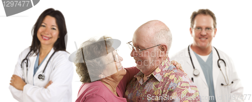 Image of Senior Couple with Medical Doctors or Nurses Behind