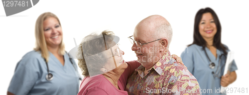 Image of Senior Couple with Medical Doctors or Nurses Behind