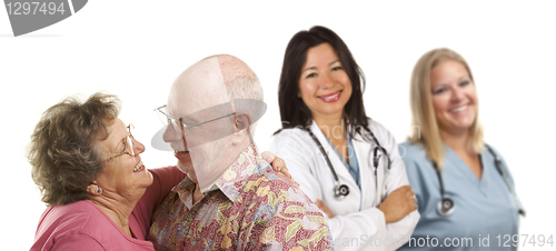 Image of Senior Couple with Medical Doctors or Nurses Behind