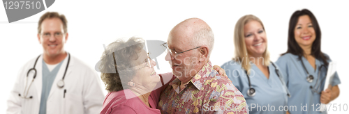 Image of Senior Couple with Medical Doctors or Nurses Behind