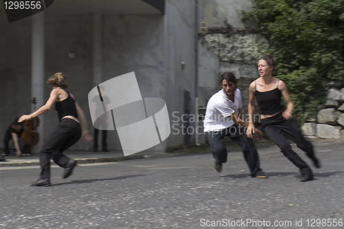 Image of Three dancers run in the street