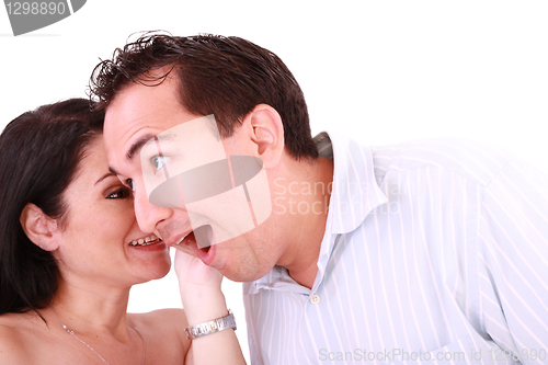 Image of girl tells something into surprised guy's ear isolated on white 
