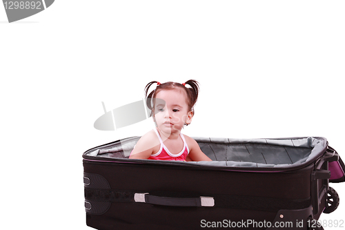 Image of little girl sitting in suitcase 