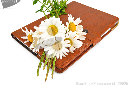 Image of Notebook with pen and daisies