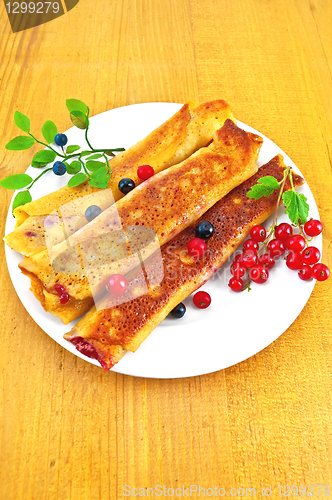 Image of Pancakes with blueberries and red currants on the board