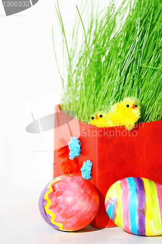 Image of Colored easter eggs and chickens in green grass