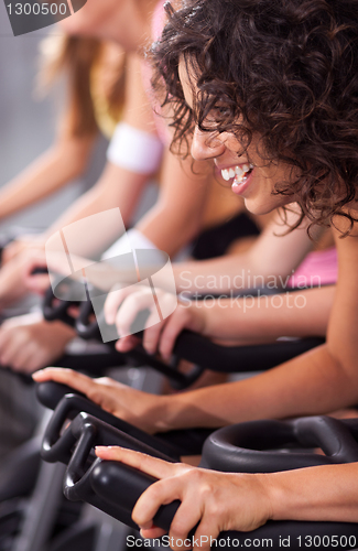 Image of Attractive females on bicycles in a gym