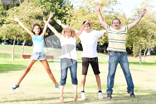 Image of Family jumping with wide-spread raised arms