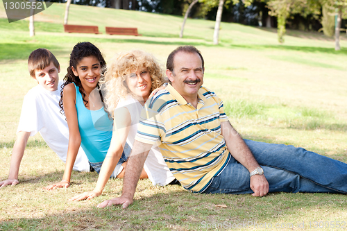 Image of Young family relaxing in park