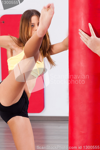 Image of Young girl kicking bag, high