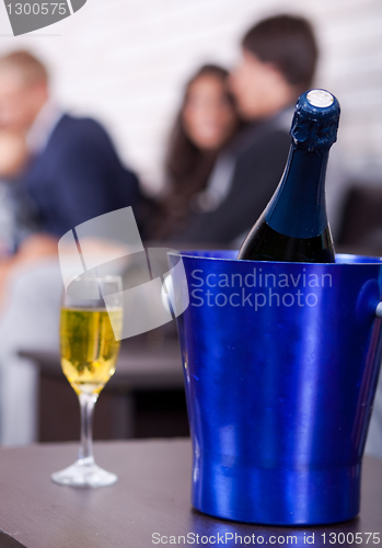 Image of Champagne in focus, couples in background