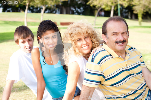 Image of Portrait of family relaxing in park