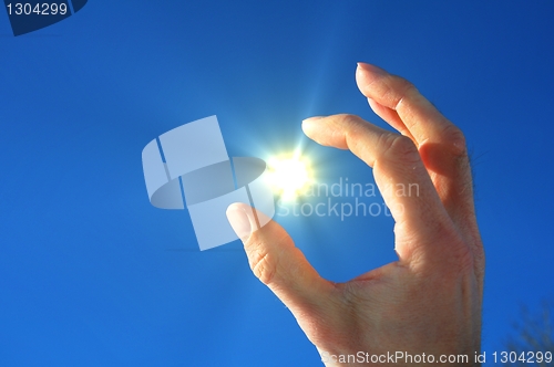 Image of hand fingers sky and sun