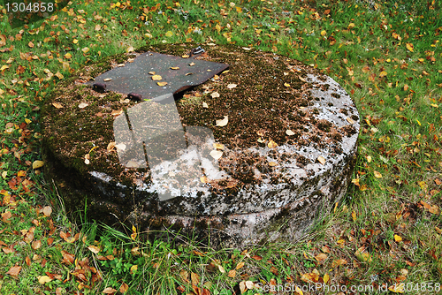 Image of typical concrete water well with moss